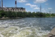 Вода естественно бурлит. На берегу со стороны электростанции видны рыбаки.